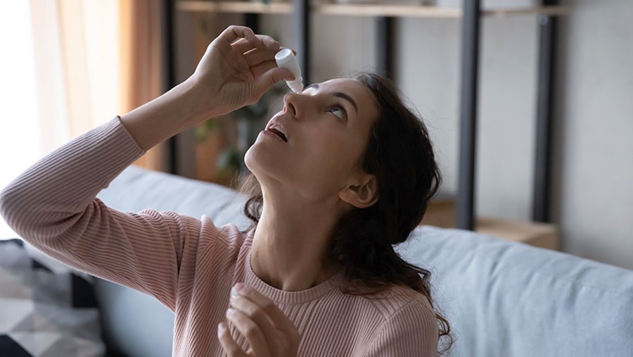 Frau, die sich zur Behandlung ihrer Pollenallergie Symptome die Augen eintopft.