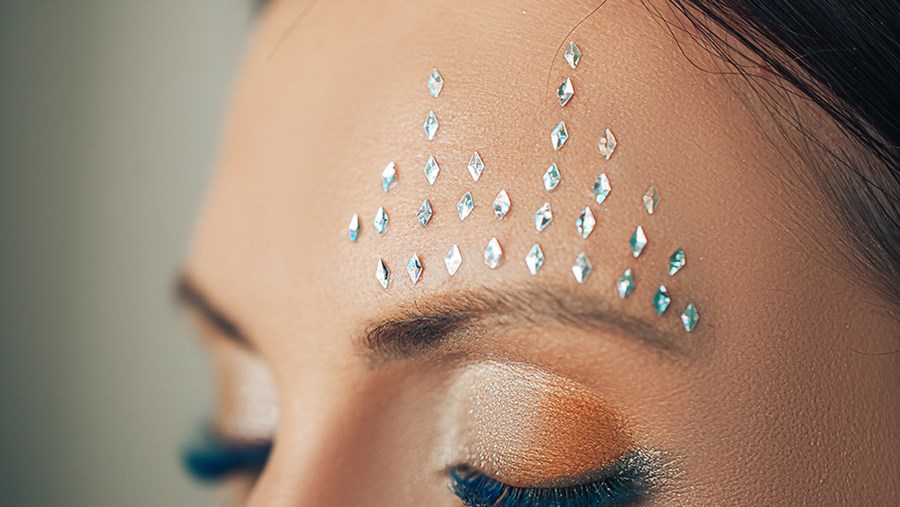 Face Gems: Frau mit Glitzersteinchen im Gesicht