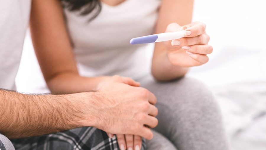 Künstliche Befruchtung durch ICSI-Methode oder IVF: Paar betrachtet Schwangerschaftstest